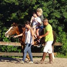 Walking a disabled boy on the horseback